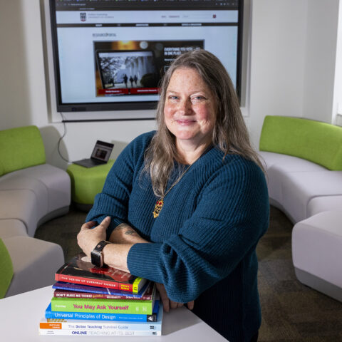 Environmental portrait of Amy Ragland, an instructional designer in the Office of Online Learning, in a common space of her office’s headquarters in Brooks Hall.