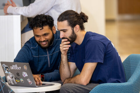 Students Venn Reddy and Ryan Majd look at a laptop in a common space at Boyd Research and Education Center on south campus.