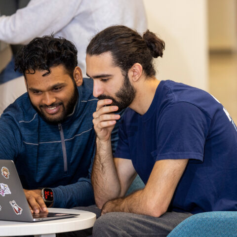 Students Venn Reddy and Ryan Majd look at a laptop in a common space at Boyd Research and Education Center on south campus.