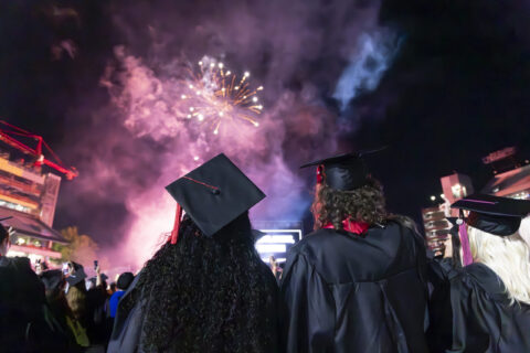 Graduating students celebrate during the fireworks display at the commencement ceremony in Sanford Stadium.