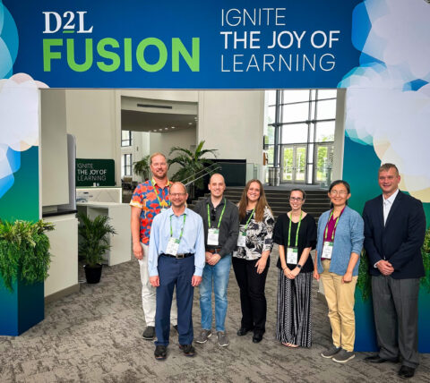 UGA Online Team members stand in front of D2L Fusion conference sign.