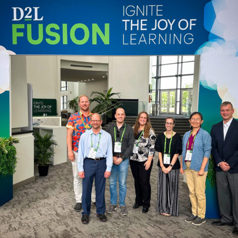 UGA Online Team members stand in front of D2L Fusion conference sign.