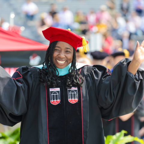 UGA doctoral graduate waves at commencement