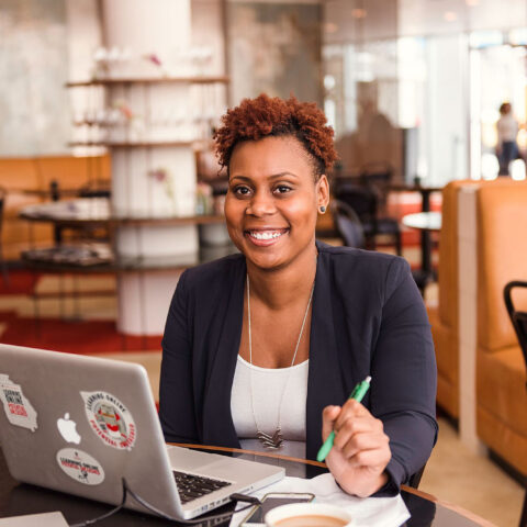 A woman works on her laptop at a coffee shop